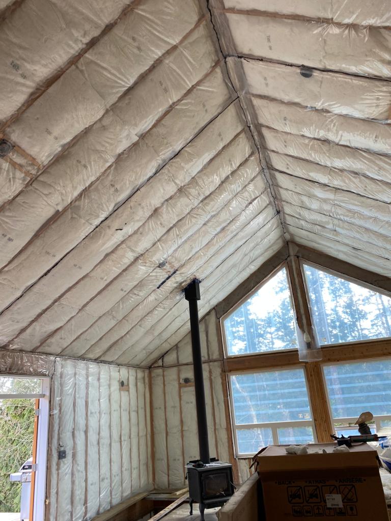 Vaulted ceiling with batt insulation installation between wooden rafters