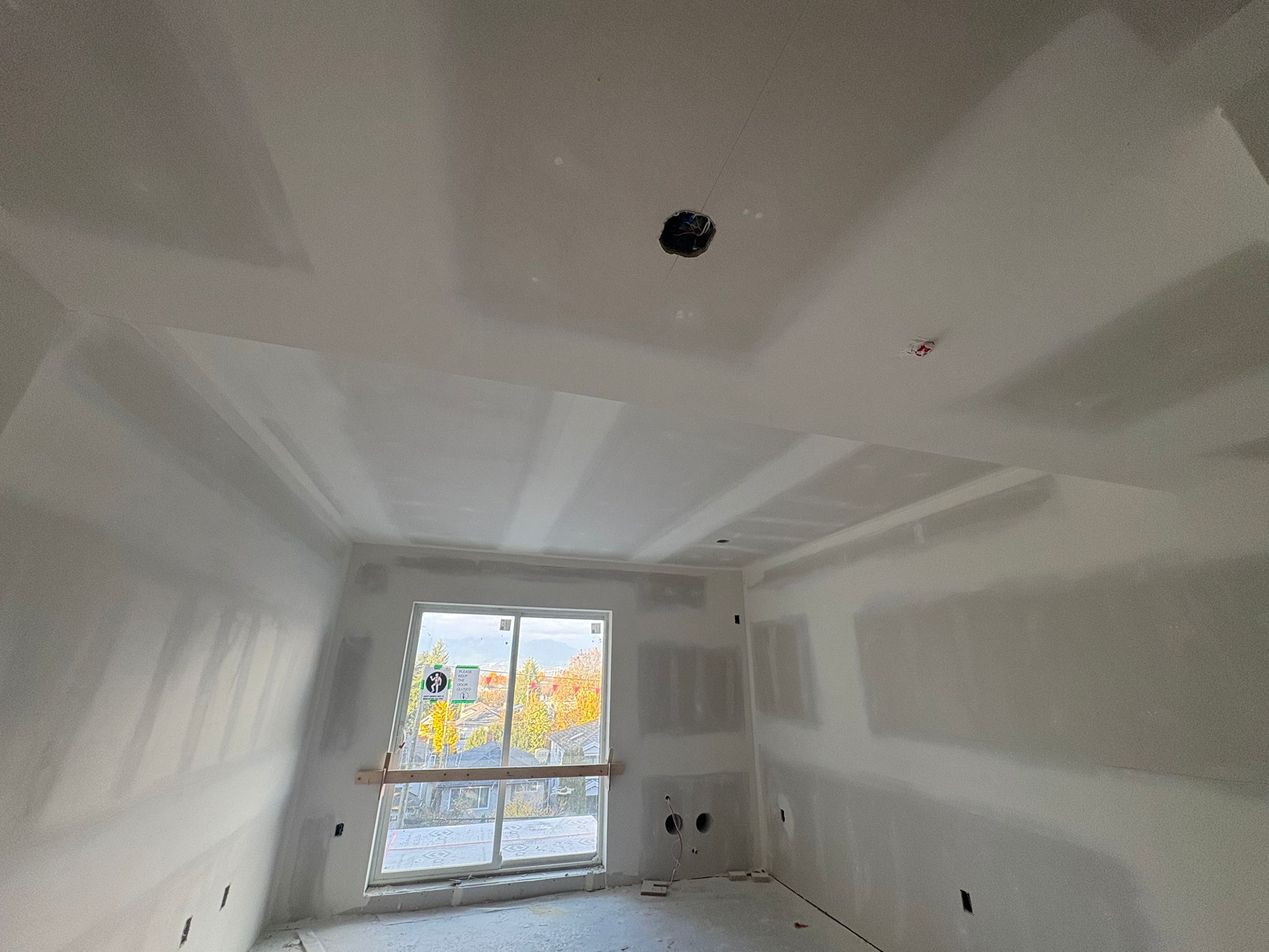 Finished drywall room with tray ceiling and smooth surfaces